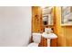 Half bath with wood paneled walls, pedestal sink and decorative mirror at 30094 Upper Bear Creek Rd, Evergreen, CO 80439