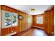 Bedroom with wood-paneled walls, hardwood flooring, and two windows providing natural light at 30094 Upper Bear Creek Rd, Evergreen, CO 80439