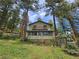 Charming two-story home with wood siding nestled among tall trees at 30094 Upper Bear Creek Rd, Evergreen, CO 80439