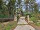 Quaint home surrounded by tall trees with a stone-lined driveway leading to the residence at 30094 Upper Bear Creek Rd, Evergreen, CO 80439