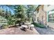 Exterior view of a log cabin with stone accents, outdoor seating, and a rustic wagon wheel decoration at 30094 Upper Bear Creek Rd, Evergreen, CO 80439