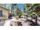 Outdoor patio with a stone table and benches, surrounded by lush trees, offering a peaceful retreat at 30094 Upper Bear Creek Rd, Evergreen, CO 80439