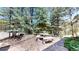 Outdoor patio area with stone benches and table, surrounded by mature trees providing shade and privacy at 30094 Upper Bear Creek Rd, Evergreen, CO 80439