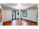 Spacious room with hardwood floors, white walls, and green-trimmed windows and doors at 30094 Upper Bear Creek Rd, Evergreen, CO 80439