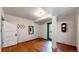 Room with hardwood floors and white walls featuring a coat rack and green-trimmed door at 30094 Upper Bear Creek Rd, Evergreen, CO 80439