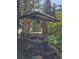 Stone well with a wooden roof surrounded by lush greenery at 30094 Upper Bear Creek Rd, Evergreen, CO 80439