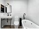Bright bathroom features textured walls, a modern sink, toilet, and a luxurious soaking tub at 960 N Pennsylvania St # 6, Denver, CO 80203
