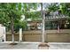 A modern townhome with attached garages and a glass-enclosed upper level, framed by mature trees and colorful flags at 960 N Pennsylvania St # 6, Denver, CO 80203