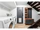 Functional laundry room with washer, dryer, storage shelves, and access to the stairs at 960 N Pennsylvania St # 6, Denver, CO 80203
