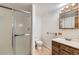 Bathroom with a glass-enclosed shower, vanity, mirror, and wood-look flooring at 11580 Depew Ct, Westminster, CO 80020