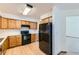 Functional kitchen with black appliances, light wood cabinets, and bright lighting at 11580 Depew Ct, Westminster, CO 80020