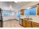 Bright kitchen showcasing stainless steel appliances, oak cabinets, and a double sink beneath large windows at 11580 Depew Ct, Westminster, CO 80020