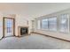 Cozy living room with a brick fireplace, built-in shelves, large windows, and plush carpet at 11580 Depew Ct, Westminster, CO 80020