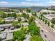 Aerial shot of a residential neighborhood, highlighting tree coverage, nearby commercial buildings, and streetscape at 8730 E Roundtree Ave, Greenwood Village, CO 80111