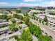 Aerial view showing the neighborhood's proximity to commercial buildings and lush trees at 8730 E Roundtree Ave, Greenwood Village, CO 80111