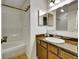 Well-lit bathroom with a tub and shower combination, vanity, sink, and mirrored medicine cabinet at 8730 E Roundtree Ave, Greenwood Village, CO 80111