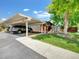 View of the carport with parking and landscaping with mature trees and well-maintained lawn at 8730 E Roundtree Ave, Greenwood Village, CO 80111