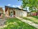Charming home featuring a lush front yard with healthy lawn, walkway and inviting landscaping at 8730 E Roundtree Ave, Greenwood Village, CO 80111