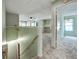 Hallway leading into a carpeted room with natural lighting and built-in bookshelves at 8730 E Roundtree Ave, Greenwood Village, CO 80111