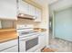 The kitchen features white appliances and a view to the living room at 8730 E Roundtree Ave, Greenwood Village, CO 80111
