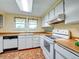 Bright kitchen featuring white appliances, tile floors, and plenty of storage space at 8730 E Roundtree Ave, Greenwood Village, CO 80111