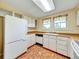 Bright kitchen with white cabinets, tile floors, and matching appliances at 8730 E Roundtree Ave, Greenwood Village, CO 80111