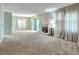 Bright living room with plush carpeting, neutral walls, and large windows with sheer curtains at 8730 E Roundtree Ave, Greenwood Village, CO 80111