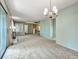 Spacious living room featuring plush carpeting and a decorative chandelier at 8730 E Roundtree Ave, Greenwood Village, CO 80111