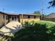 Backyard featuring overgrown grass, concrete patio and brick facade on home at 588 Empire St, Aurora, CO 80010