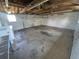 A spacious garage with concrete flooring, exposed ceiling beams, and a large roll-up door at 588 Empire St, Aurora, CO 80010