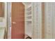 Bedroom closet featuring adjustable white shelves and a wooden door at 13800 E Marina Dr # 112, Aurora, CO 80014