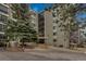 Exterior view of a multi-story apartment building with large trees and well-maintained landscaping at 13800 E Marina Dr # 112, Aurora, CO 80014