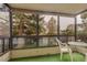 Enclosed sunroom with a table and chairs, providing a view of trees and greenery at 13800 E Marina Dr # 112, Aurora, CO 80014
