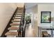Hallway view showing a staircase and view into the dining area with updated lighting fixture at 6856 S Broadway, Centennial, CO 80122