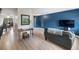 Cozy living room featuring a modern sofa, accent wall, and hardwood floors at 6856 S Broadway, Centennial, CO 80122