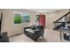 Living room with a comfortable couch, a large window, and view of the stairs at 6856 S Broadway, Centennial, CO 80122