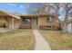 Charming brick home with mature tree, covered front porch, and attached carport at 4940 Fenton St, Denver, CO 80212