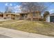 Charming brick home with mature tree, covered front porch, and attached carport at 4940 Fenton St, Denver, CO 80212