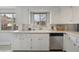 A kitchen featuring a stainless steel dishwasher, white cabinets and views of the outdoors at 4940 Fenton St, Denver, CO 80212