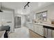 A bright kitchen with stainless steel appliances, white cabinets and neutral tile floor at 4940 Fenton St, Denver, CO 80212
