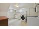 Bright laundry room with washer, dryer, built-in cabinets, and tiled floor at 4940 Fenton St, Denver, CO 80212