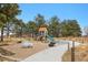 Community playground with slide, sand pit, and picnic tables surrounded by trees at 4940 Fenton St, Denver, CO 80212