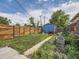 Spacious backyard with a wooden fence, a shed, and a well-maintained lawn offers relaxation at 66 E 45Th Ave, Denver, CO 80216
