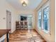 Bright dining room with wood-look flooring, large windows, and a view to the updated kitchen at 66 E 45Th Ave, Denver, CO 80216