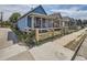 Exterior view of a charming blue house with a well-maintained yard and a quaint wooden fence at 66 E 45Th Ave, Denver, CO 80216