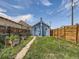 Charming blue home with a brick chimney, garden beds, and a wood fence at 66 E 45Th Ave, Denver, CO 80216
