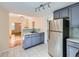Modern kitchen with stainless steel refrigerator, gray cabinets, and access to the living area at 66 E 45Th Ave, Denver, CO 80216