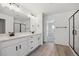 Well lit bathroom with double sink vanity, a glass shower, and a walk in closet at 1324 Sienna Peak Cir, Erie, CO 80516