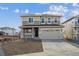 Two-story home with a two-car garage, covered porch, and a front yard ready for landscaping at 1324 Sienna Peak Cir, Erie, CO 80516