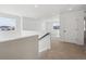 Upstairs hallway with windows overlooking a bright and spacious landing area with neutral carpet at 1324 Sienna Peak Cir, Erie, CO 80516